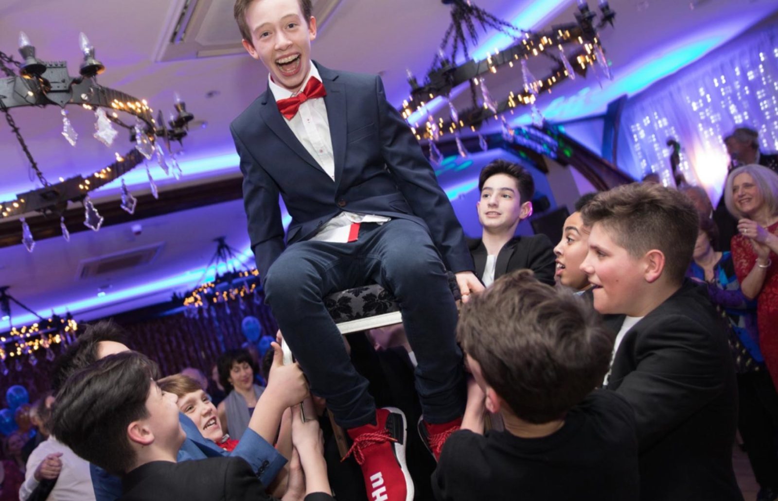 Image of a Bar mitzvah boy being balanced high above on a chair